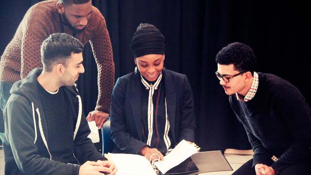 A diverse group of young people discuss theatre direction